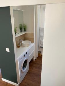 a bathroom with a sink and a washing machine at Les cèdres in Uzès
