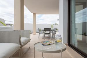una sala de estar con una mesa con gafas. en HomeForGuest Flat with large terrace in modern residential complex with swimming pool, en Caleta de Fuste