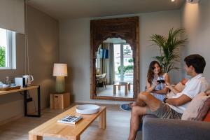 a man and a woman sitting on a couch in a living room at Quinta da Abelheira in Ponta Delgada