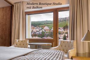 a bedroom with a bed and a window with a view at Hotel Arte in St. Moritz