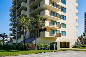 a tall apartment building with palm trees in front of it at Santa Rosa Dunes 923 in Pensacola Beach