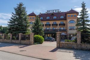 un hotel con una valla frente a un edificio en Hotel Ruczaj, en Cracovia