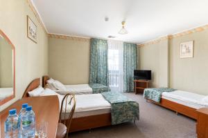 una habitación de hotel con dos camas y una mesa en Hotel Ruczaj, en Cracovia 6 fotos más