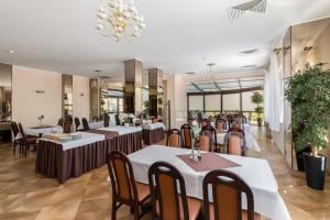 a restaurant with tables and chairs and a chandelier at Hotel Ruczaj in Krakow