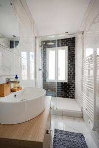 biała łazienka z wanną i prysznicem w obiekcie Le Petit Drancy - T2 tout équipé w mieście Drancy
