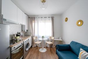 een woonkamer met een blauwe bank en een tafel bij Le Petit Drancy - T2 tout équipé in Drancy