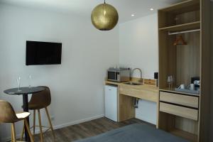 a small kitchen with a counter and a table at nuit sur le pont 4 in Landerneau
