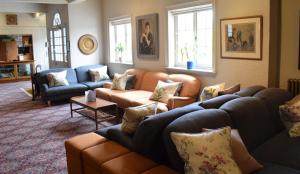 una sala de estar con sofás, mesas y ventanas en Knoll House en Studland