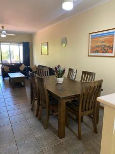 comedor y sala de estar con mesa de madera y sillas en Broome, en Broome