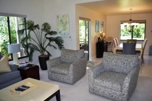 sala de estar con 2 sillas y mesa en Eagles Nest Florida, en Naples