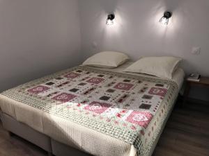 Un dormitorio con una cama con una colcha encima en Appartement 8 personnes à 3 minutes des pistes, en Le Dévoluy