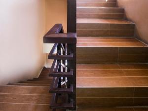 a wooden stair case with a wooden stool on it at Rjat Guesthouse in Biñan