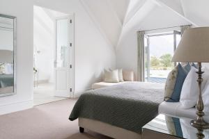 a white bedroom with a bed and a window at Boschendal Farm Estate in Franschhoek