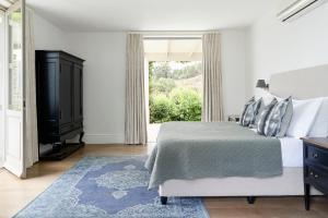 a bedroom with a bed and a large window at Boschendal Farm Estate in Franschhoek