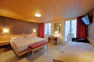 um quarto de hotel com duas camas e uma televisão em Hotel Rössli em Interlaken