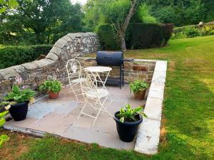 een patio met een tafel, stoelen en planten bij Low Nook Farm Holiday Cottage in Brampton