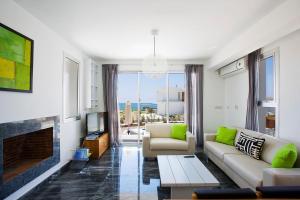 ein Wohnzimmer mit einem Sofa und einem Kamin in der Unterkunft Luxury Cyprus Villa Sky Villa Private Pool Sea View 1 BDR Paphos in Paphos