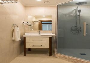 a bathroom with a sink and a shower at Boutique Hotel Kaspi in Temirtaū +37 photos