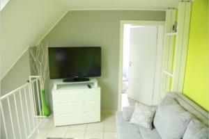 un soggiorno con TV su un comò bianco di Modernes Apartment in Leichlingen a Leichlingen