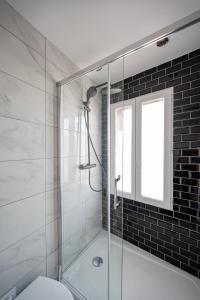 a bathroom with a glass shower with a toilet at Le Petit Drancy - T2 tout équipé in Drancy