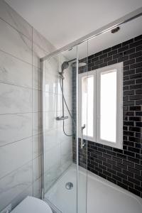 a bathroom with a glass shower with a toilet at Le Petit Drancy - T2 tout équipé in Drancy +4 photos