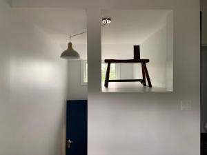 a wooden table in a white room with a lamp at South Landing Inn in Niagara-on-the-Lake