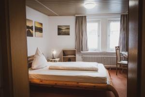 a bedroom with a bed and a desk and a window at Restaurant / Pension Mainzer Tor in Alsfeld