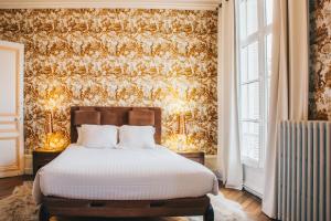 una camera con un letto con due lampade e una parete di Chateau Du Landin a Le Landin