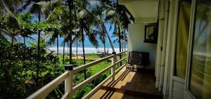 uma varanda de uma casa com vista para a praia em White Shell Beach House em Cananor