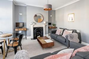 ein Wohnzimmer mit einem Sofa und einem Tisch in der Unterkunft Modern & Spacious 2 Bedroom Maisonette in Bath