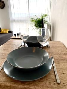 uma mesa com um prato e dois copos em L'INDUSTRIEL CHIC, 2 PIECES AVEC VU IMPRENABLE SUR ROUEN em Rouen