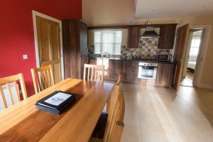 een keuken met een houten tafel en een eetkamer bij Country View, Holiday Home Dungarvan, Waterford - 3 Bedrooms Sleeps 6 in Dungarvan