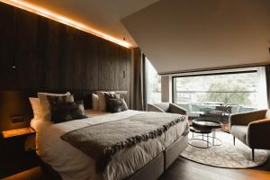 een slaapkamer met een groot bed en een tafel en stoelen bij Hotel Sanglier in Durbuy