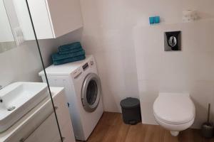 une petite salle de bains avec un lave-linge et des toilettes. dans l'établissement Nowoczesny apartament przy Aquapark Reda, à Reda