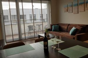 a bottle of wine sitting on a table with two glasses at Nowoczesny apartament przy Aquapark Reda in Reda