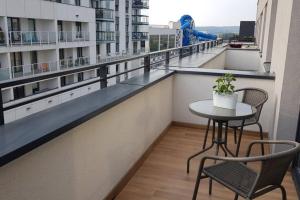 a balcony with a table and chairs on a building at Nowoczesny apartament przy Aquapark Reda in Reda