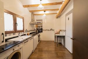 a kitchen with white cabinets and a sink at LAGAR DEL PALOMAR in Teruel