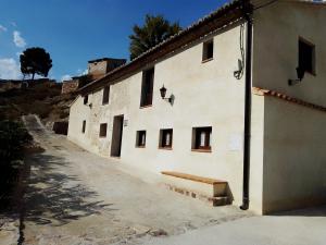 duży biały budynek z oknami i chodnikiem w obiekcie LAGAR DEL PALOMAR w mieście Teruel