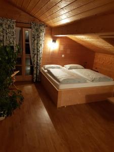 ein Schlafzimmer mit einem Bett in einem Holzzimmer in der Unterkunft Beim Melchern in Fischbachau