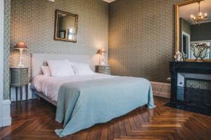a bedroom with a bed and a fireplace and a mirror at Chateau Du Landin in Le Landin