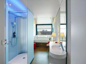 a bathroom with a shower and a sink and a toilet at citizenM Tower of London in London