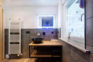 uma casa de banho com um lavatório com uma tigela num balcão de madeira em Honey apartments em Žirovnica