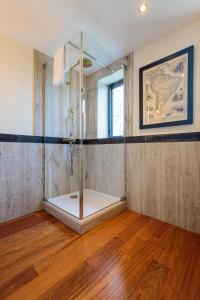 eine Duschkabine in einem Zimmer mit Holzboden in der Unterkunft Parrot World - Les Lodges in Crécy-la-Chapelle