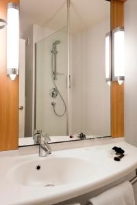 La salle de bains est pourvue d'un lavabo et d'une douche. dans l'établissement Hotel ibis Leiria Fatima, à Leiria