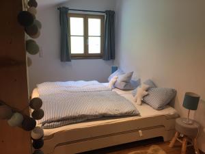 una camera da letto con letto, cuscini e finestra di Alpin Chalet Kern a Klösterle am Arlberg