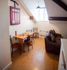 a living room with a table and a couch at Albion Guest House & Apartments in Pembroke Dock