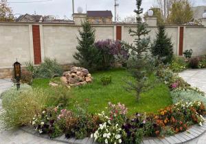 um jardim com um ramo de flores num quintal em Boutique Hotel Kaspi em Temirtaū