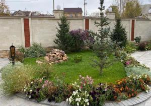 a garden with a bunch of flowers in a yard at Boutique Hotel Kaspi in Temirtaū
