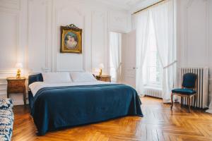 a white bedroom with a bed and a chair at Chateau Du Landin in Le Landin +83 photos