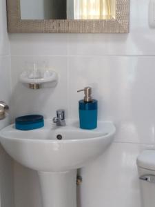 a white bathroom with a sink and a mirror at Hospedaje de Lidia in Lima